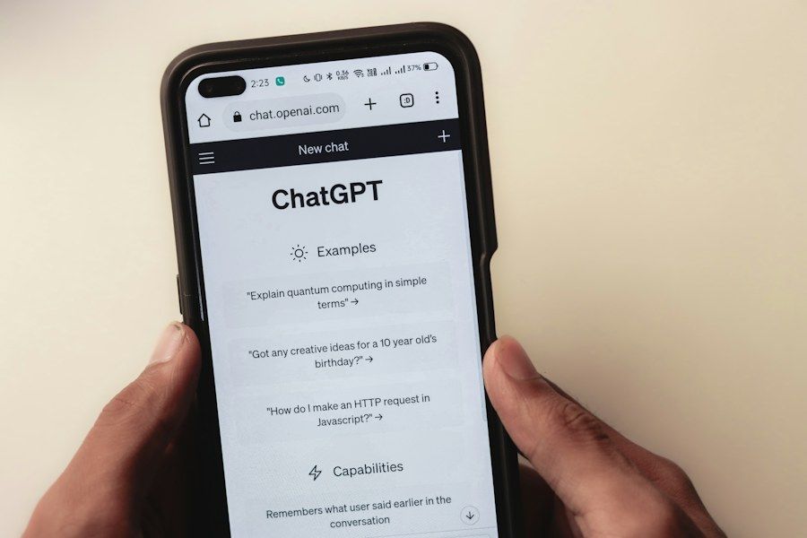 Руки тримають телефон з відкритим чатом ChatGPT